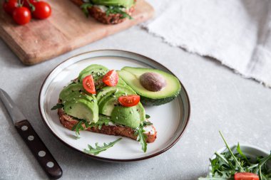 Avokado ve lezzetli kepekli tost ile sağlıklı bir kahvaltı. Tost ekmeğine baharatlı avokado dilimi. Meksika mutfağı