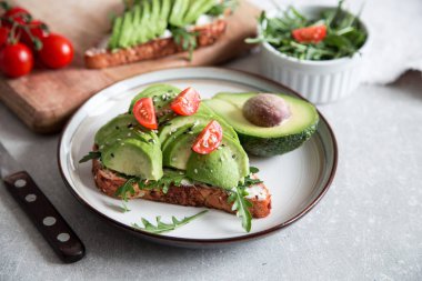 Avokado ve lezzetli kepekli tost ile sağlıklı bir kahvaltı. Tost ekmeğine baharatlı avokado dilimi. Meksika mutfağı