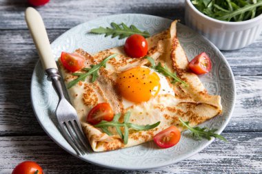 Yumurta, peynir, arugula yaprakları ve domates ile krep. Galette c