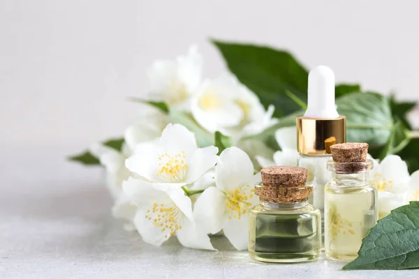 Essential jasmine oil. Massage oil with jasmine flowers on a woo — Stock Photo, Image