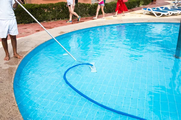 Hombre limpiando una piscina en verano. Limpiador de la natación —  Fotos de Stock