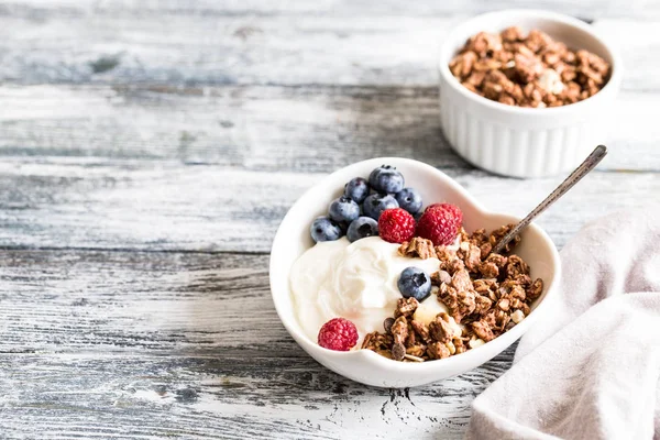 Yogur griego, arándanos, frambuesas y granola en un bo blanco —  Fotos de Stock