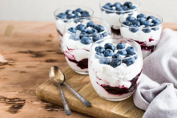 Domácí dezert s řeckými jogurty a smetanou, borůvkový džem a — Stock fotografie