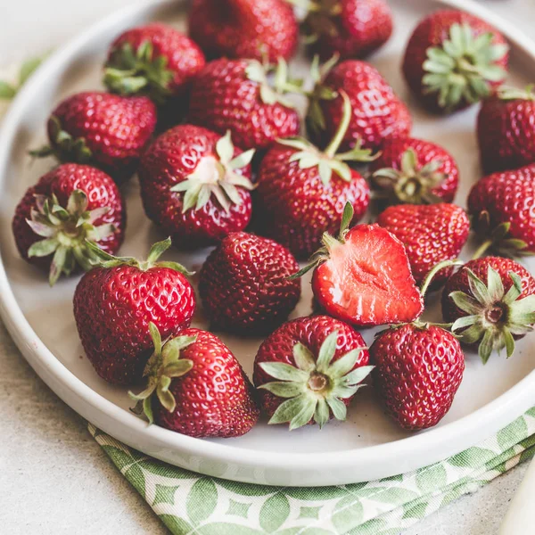 Fresas jugosas maduras en un plato de arcilla sobre un fondo claro wi — Foto de Stock