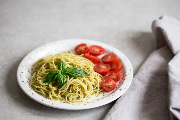 Spaghetti with homemade pesto sauce, basil leaves and  tomatoes/