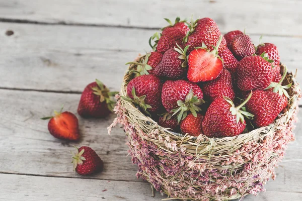 Fresas maduras en una hermosa cesta sobre un fondo de madera w — Foto de Stock