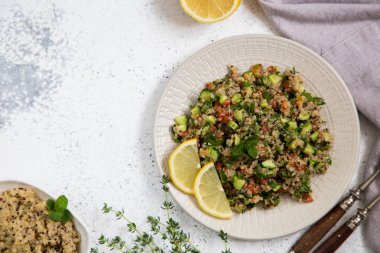 Taze domates, salatalık ve salata yaprakları ile Quinoa salatası. Su