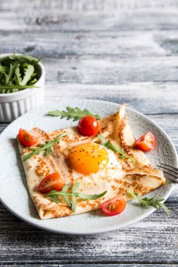 Yumurta, peynir, arugula yaprakları ve domates ile krep. Galette c