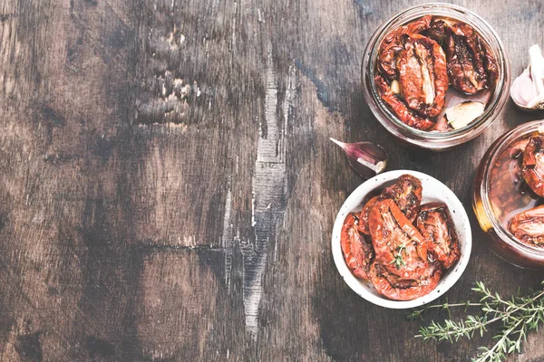 Sun dried tomatoes with olive oil in a jar on wooden background/ — 스톡 사진