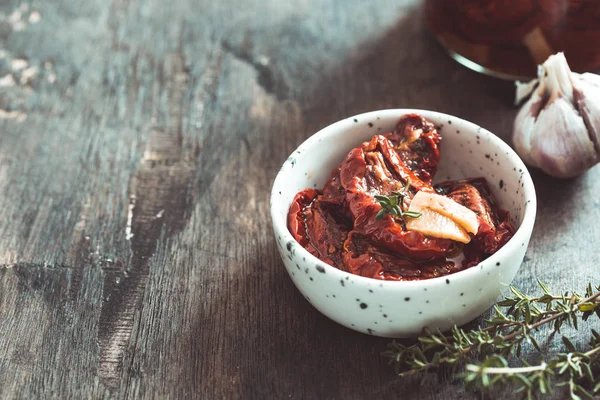 어두운 나무 배경에 놓인 접시에 놓인 햇볕에 말린 토마토. — 스톡 사진