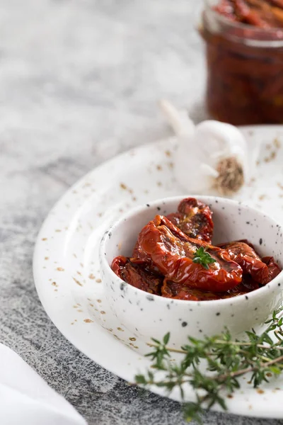 얇은 콘크리트 배경에 놓인 접시에 놓인 햇볕에 말린 토마토 — 스톡 사진