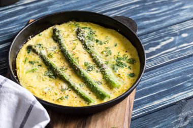 Çırpılmış yumurtalı kuşkonmaz. Kızartma tavasında kuşkonmaz ile omlet..