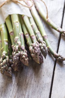 yeşil kuşkonmaz. Gri ahşap bir arka planda bir sürü yeşil kuşkonmaz