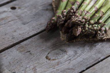 yeşil kuşkonmaz. Gri ahşap bir arka planda bir sürü yeşil kuşkonmaz