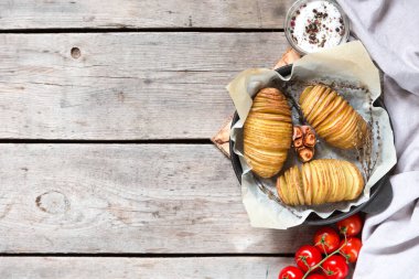 Hasselback patatesleri. Tahta masada tavada fırında patates.