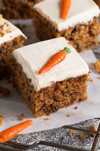 pieces of carrot cake with walnuts with icing cream on a light background. tinting. selective focus/