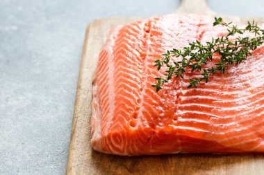 Somon balığı. Pişirme malzemeleri, otlar ve limonla taze çiğ somon balığı filetosu. Kapatın. sağlıklı yemek, diyet veya yemek pişirme konsepti