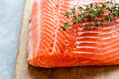 Somon balığı. Pişirme malzemeleri, otlar ve limonla taze çiğ somon balığı filetosu. Kapatın. sağlıklı yemek, diyet veya yemek pişirme konsepti