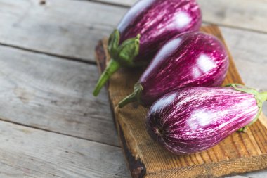 Tahta kesme tahtasındaki taze patlıcanlar.