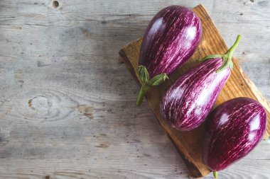 Tahta kesme tahtasındaki taze patlıcanlar.