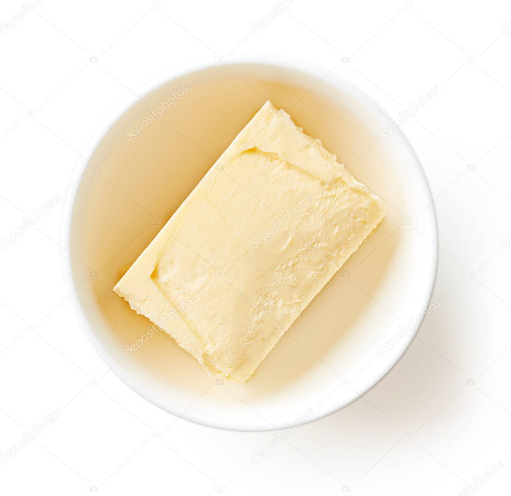 Butter in clay bowl isolated on white background, top view