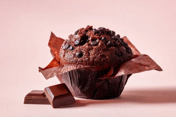 Muffin Chocolate Papel Marrón Con Trozos Chocolate Sobre Fondo Rosa —  Fotos de Stock