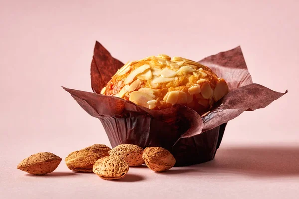 Muffin Almond Dalam Kertas Coklat Dengan Almond Dikupas Pada Latar — Stok Foto