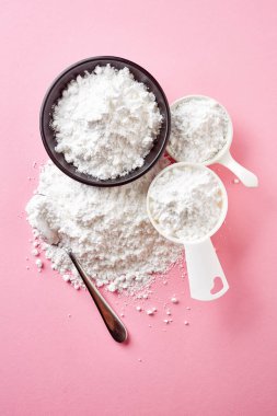 Siyah kase ölçme kaşık toz ve kaşık toz şeker ile pembe, üstten görünüm