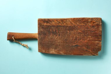 Ahşap kesme tahtası üzerinde mavi arka plan, üstten görünüm