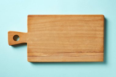 Ahşap kesme tahtası üzerinde mavi arka plan, üstten görünüm