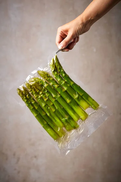 Hand Tweezers Holding Asparagus Sous Vide Bag Stone Wall Background — Stock Photo, Image