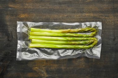 Kuşkonmaz vakum ahşap ta üzerinde sous vide pişirme için hazır mühürlü