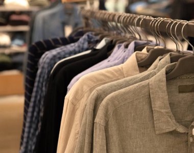 Giyim bir rafta asılı. Bez askıları gömlek ile. Mens iş elbiseleri