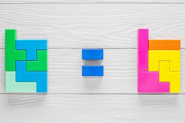 İki özdeş geometrik figürler farklı öğelerden oluşur. İki rakamlar ve bir işaret aralarında eşittir. Mantıksal düşünme kavramı. Ahşap arka plan üzerinde geometrik şekiller. Tetris oyuncak blokları