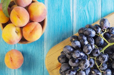 Taze olgun şeftali ve ahşap arka plan, üstten görünüm üzerinde kırmızı üzüm. Sağlıklı gıda arka plan.