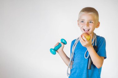 Mutlu portre, çocuk gülümseyen bir kırmızı elma yiyor. Bir elma tutan komik çocuk. Kameraya bakıyor. Sağlıklı bir yaşam tarzı, Organik Vejetaryen yiyecekler kavramı.