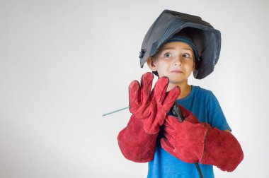 Mutlu çocuk kaynakçı maskesi ve kaynak cihazları. Kaynak Ekipmanı, maske, koruyucu deri eldiven, kaynak elektrotları kaynak. Eğlenceli kavramı. Çocuk gelecekteki mesleği rüya. Kariyer seçimi. 