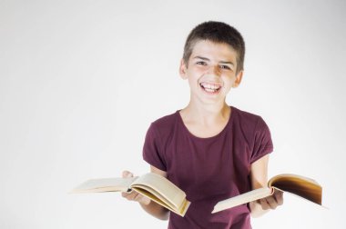 Çocuk tutan iki açık kitap gülümseyen mutlu portre. Genç gülümseyen ve kameraya bakıyor. Çocuk holding kitaplar. Okula geri kavramı.