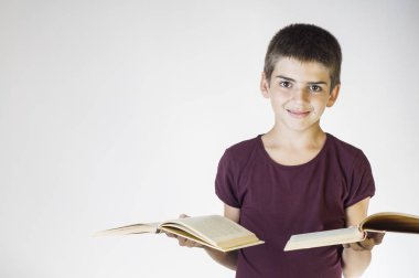 Çocuk tutan iki açık kitap gülümseyen mutlu portre. Genç gülümseyen ve kameraya bakıyor. Çocuk holding kitaplar. Okula geri kavramı.