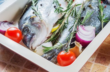 Taze çiğ balık Dorado limon, biberiye ve baharat Pişirme tepsisi içinde.