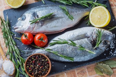 Taze balık Dorado limon, biberiye ve siyah arduvaz gemide baharat.