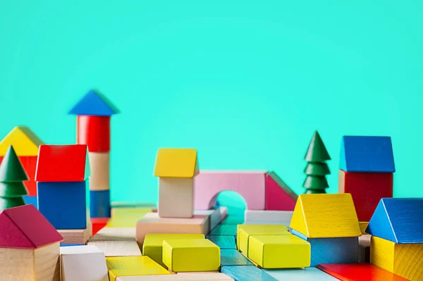 玩具木房子从颜色的块在蓝色背景 施工理念 房地产 建造一个房子从一个木制立方体 在办公桌上 — 图库照片