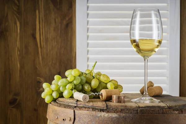 コピー スペースを持つ木製の樽と白ワインの静物 ワインの瓶 白ワインのガラス 古い木樽にブドウの房 ワインの試飲と生産の概念 — ストック写真