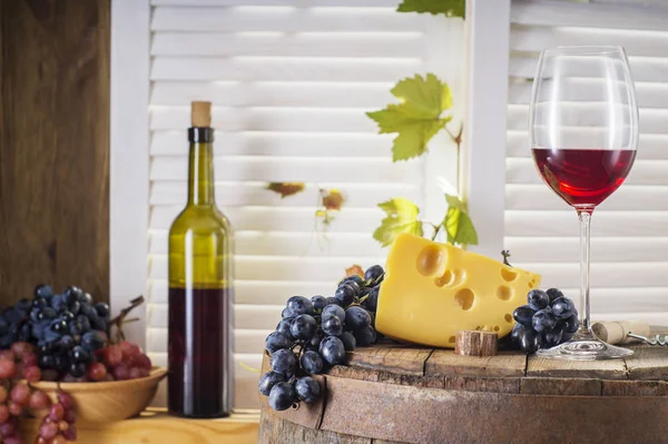 木製の樽と赤ワインの静物 ワイン ボトル チーズと古い木樽にブドウの赤ワインのガラス ワインの試飲と生産の概念 — ストック写真