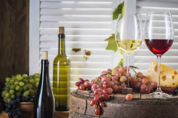 メガネの白と赤のカップルの静物の木製樽ワイン ワイン ボトル 白と赤のワインはチーズと古い木樽にブドウのメガネ ワインの試飲と生産の概念 — ストック写真
