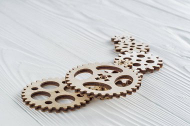Beyaz ahşap zemin üzerinde dişli tekerlekleri. Yaratıcı, mantıksal düşünme kavramı.