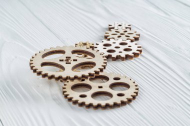 Beyaz ahşap zemin üzerinde dişli tekerlekleri. Yaratıcı, mantıksal düşünme kavramı.