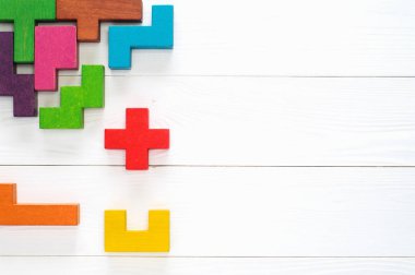 Yaratıcı, mantıksal düşünme kavramı. Beyaz ahşap arka plan, düz yatıyordu, farklı renkli şekiller ahşap blok alanı kopyalayın. Geometrik şekiller farklı renklerde, üstten görünüm. Arka plan.
