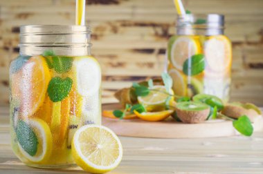 Nane ile taze limonata. Ahşap masa meyve suyu detoks. Yaz bir mason kavanoza bir bambu tabloda narenciye su yenileniyor. Limon, portakal, Kivi Meyve kokteyli.