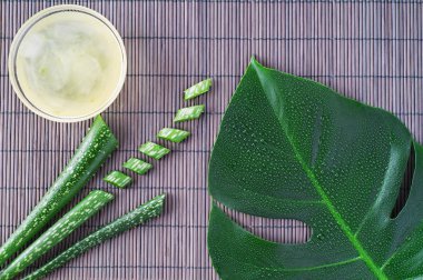 Aloe vera jel ahşap masa yapraklarda aloe vera ile. Doğal kozmetik maddeler. Taze aloe vera bitki ahşap tahta, düz üzerinde yatıyordu. Spa kavramı, üstten görünüm.